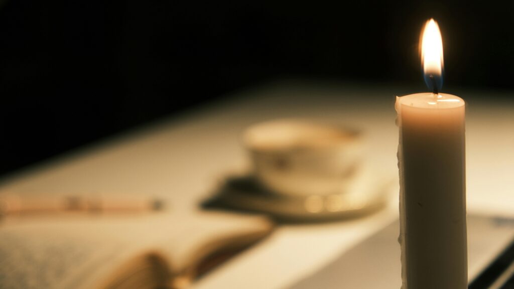 Une atmosphère chaleureuse à la lumière de la bougie avec un livre ouvert et une tasse de thé pour un moment apaisant.